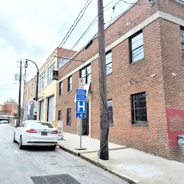 Exterior of Anh's Kitchen, a brick building with a white car parked on the street.